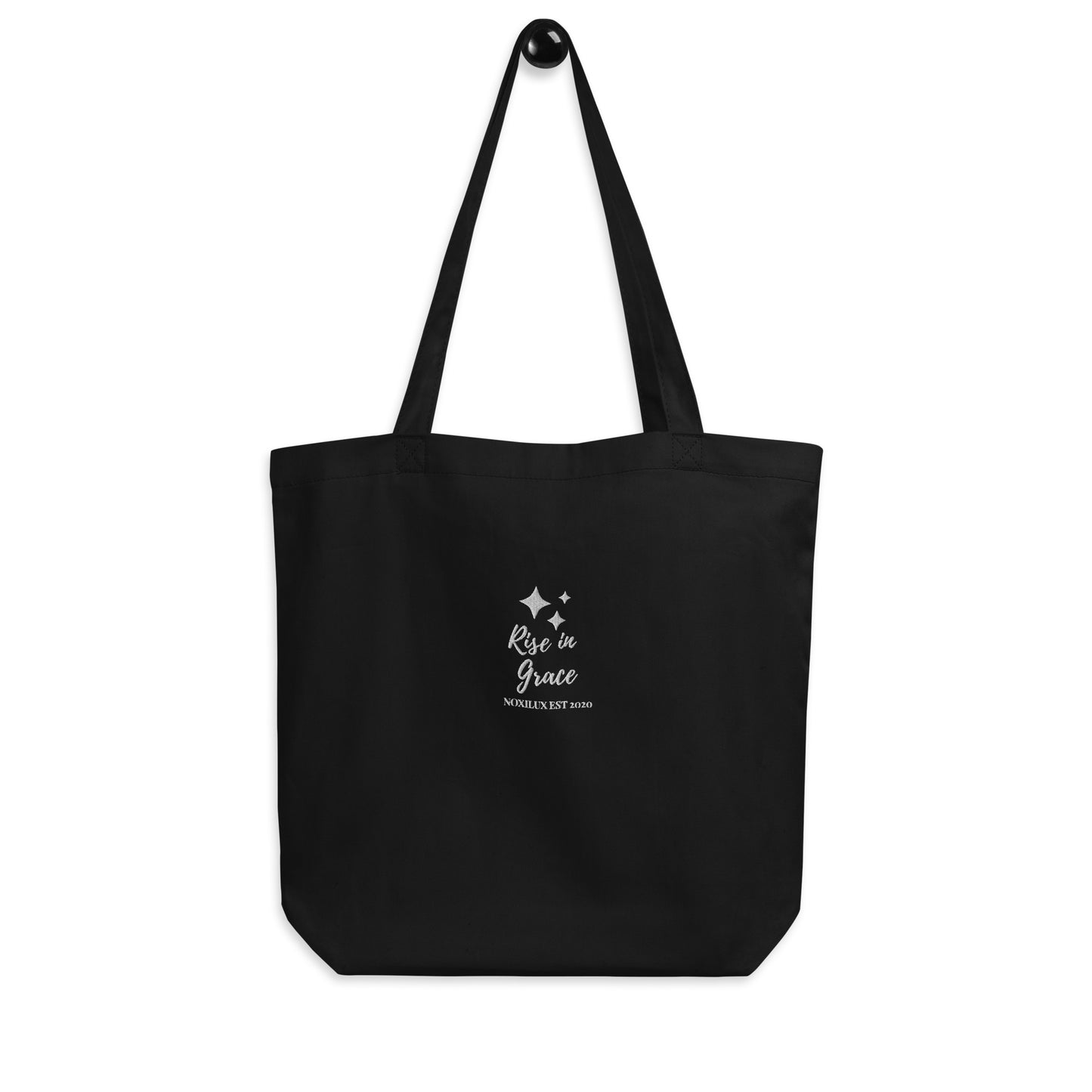 Black shopping tote bag with 'rise in grace.' text and a sparkle symbol on a white embroidered. Eco-friendly organic cotton.