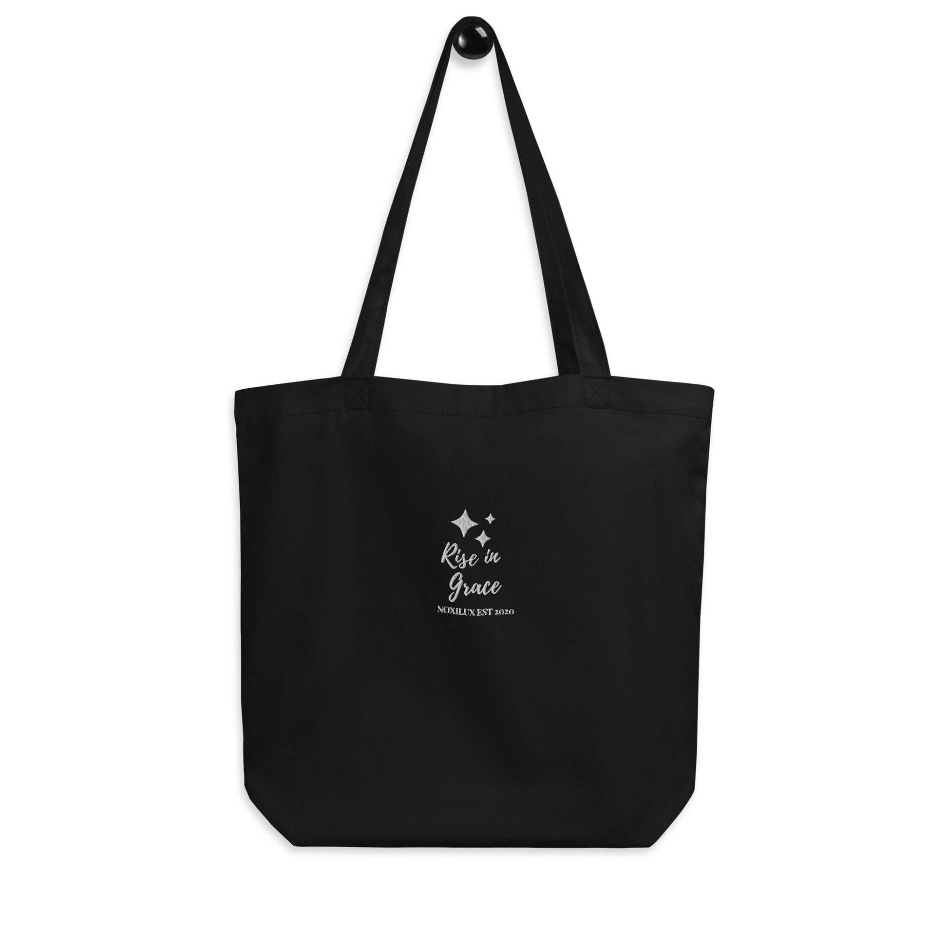 Black shopping tote bag with 'rise in grace.' text and a sparkle symbol on a white embroidered. Eco-friendly organic cotton.